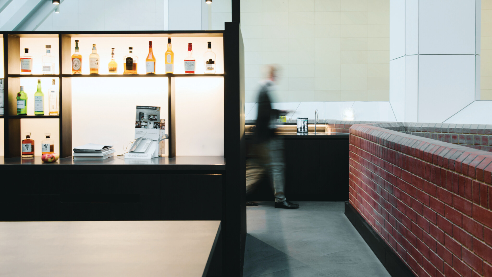 Figure rushing past a TopBrewer Coffee machine installed in an open plan area near a bar