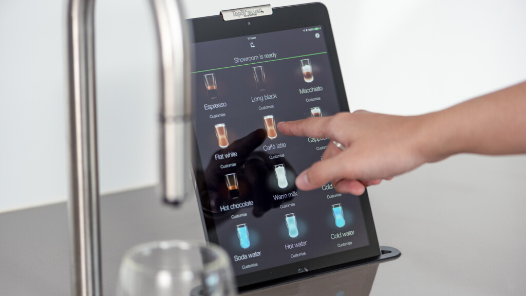 Employee selecting their coffee using the self serve iPad interface that comes with the TopBrewer coffee machine